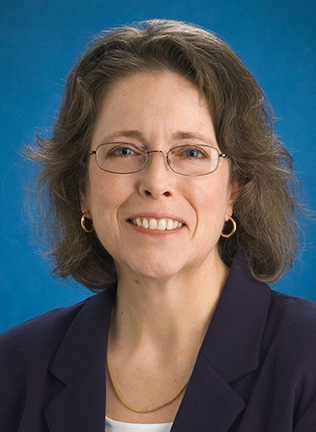 White woman with medium brown hair wearing a black top