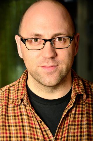 Photo of author Daniel Kraus, a Caucasian man with glasses, a shaved head, and light goatee